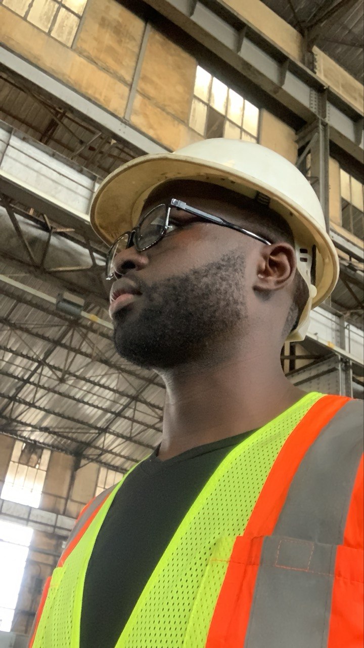 Donfack Fortune on site in a CAMRAIL workshop, wearing a hard hat and high-visibility vest